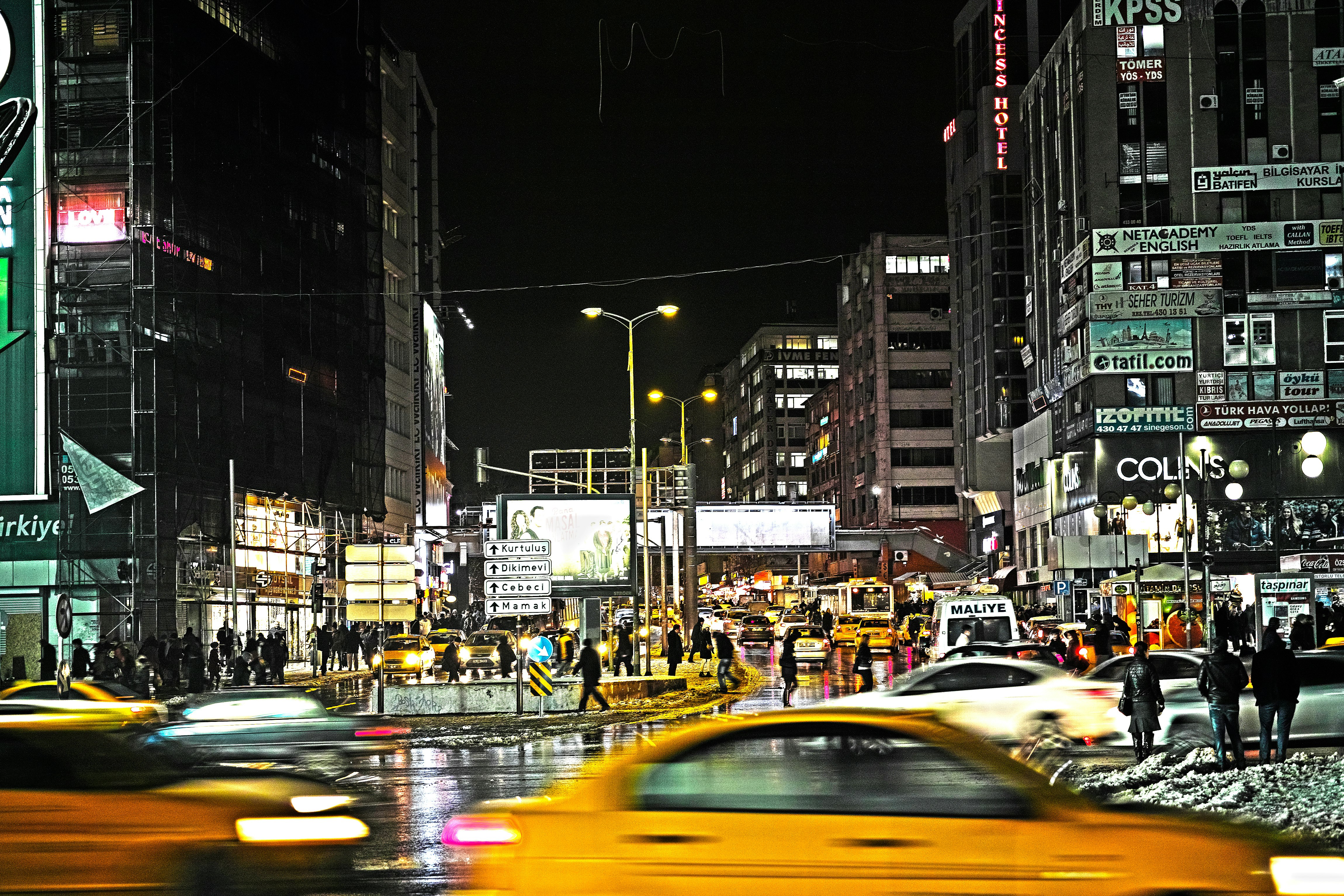 cars on road between buildings during night time